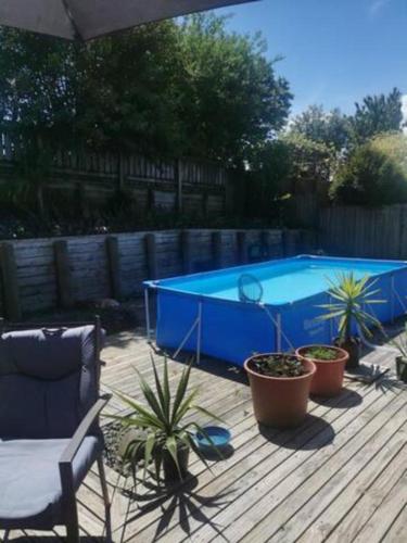 una piscina con macetas y sombrilla en Double Room Free WIFI, en Hamilton