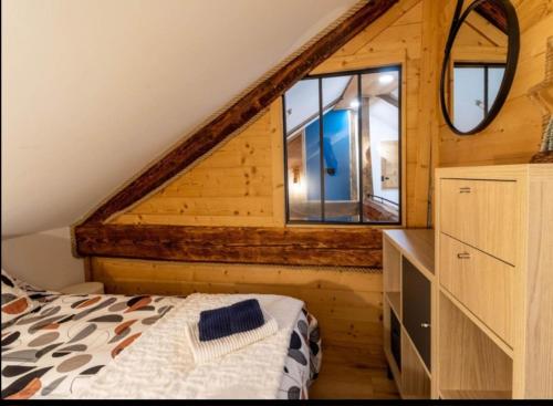 une chambre avec un lit et une commode avec un miroir dans l'établissement Appartement de charme rénové 