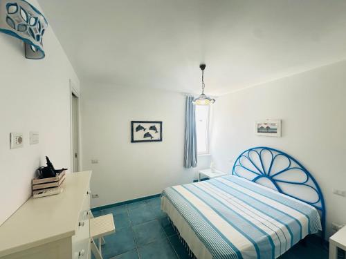 a white bedroom with a bed and a window at Acquario - Immobilevante in Ponza