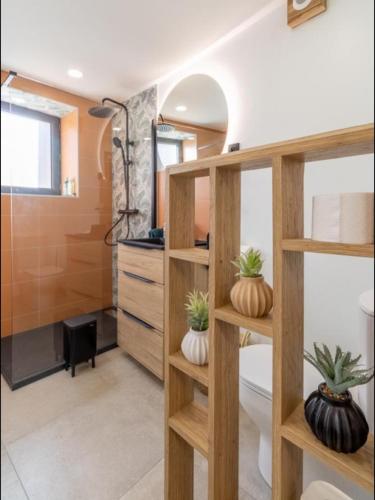 une salle de bain avec des étagères en bois contenant des citrouilles dans l'établissement Appartement de charme rénové 