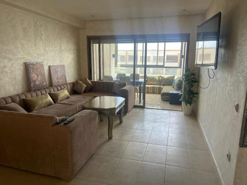a living room with a couch and a table at Sunny modern Apartment- Ocean & Pool view in Al Mansouria in Mansouria