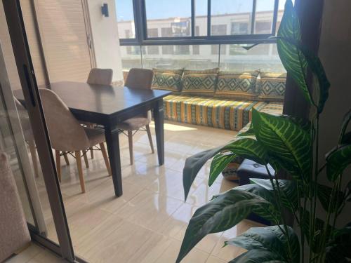 a dining room with a table and chairs and a window at Sunny modern Apartment- Ocean & Pool view in Al Mansouria in Mansouria