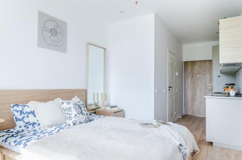 een slaapkamer met een groot bed met blauwe en witte kussens bij Nemunas A respite Studio 8 in Druskininkai