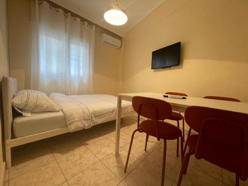 a bedroom with a bed and a table with chairs at Mimicry Apartment in Nea Plagia