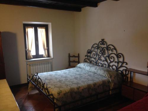 een slaapkamer met een bed en een raam bij Aia dell'Orso in Campoli Appennino