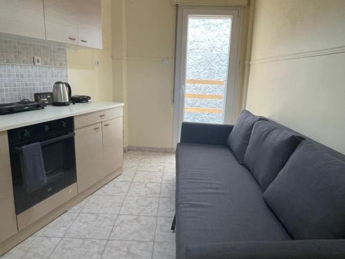 a living room with a blue couch in a kitchen at Mimicry Apartment in Nea Plagia