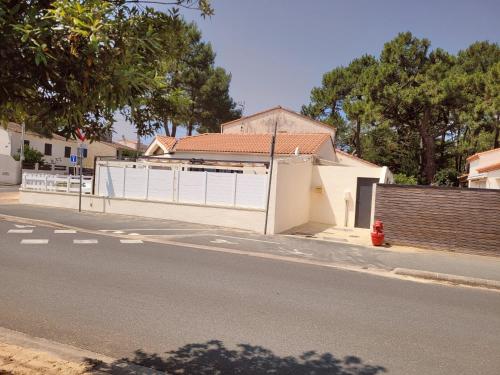 une rue avec une clôture blanche et une maison dans l'établissement Maison Princesse, à La Tranche-sur-Mer