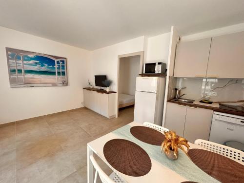 une cuisine et une salle à manger avec une table dans une pièce dans l'établissement Paradis- 4 PERS, Neuf, Hyper centre ! Plage à 2 mn- Climatisé, à Saint-Raphaël