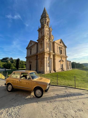 an old car parked in front of an old church at Alberto Charming Home in Montepulciano
