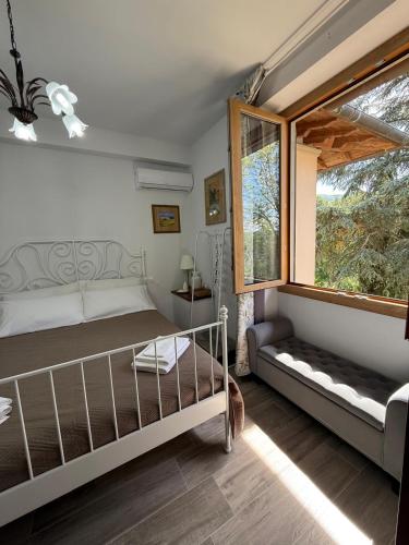 a bedroom with a bed and a large window at Villa Casavecchia Caselli in Dicomano