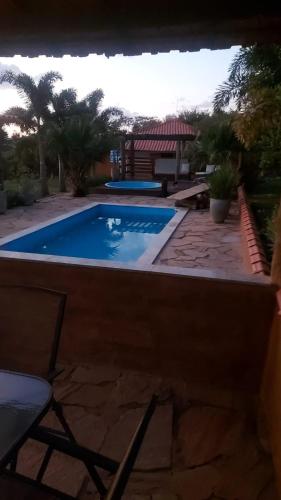 a pool in a yard with a chair next to it at Pousada Portal da Serra in Carrancas