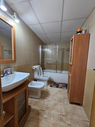 een badkamer met een wastafel, een toilet en een bad bij BlancMar Peñiscola in Peñíscola