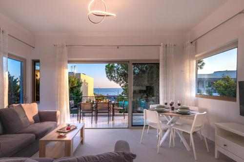 a living room with a couch and a table at Era Suites Lagonisi in Kalívia Thorikoú