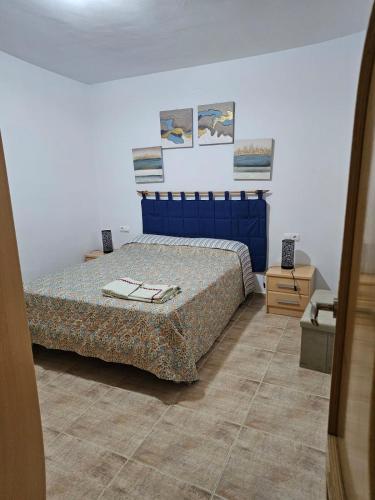 een slaapkamer met een bed met een blauw hoofdeinde bij BlancMar Peñiscola in Peñíscola