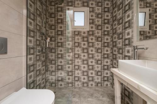 a bathroom with a toilet and a sink at Villy Suites - Zante Luxury Suites near the Sea in Argassi