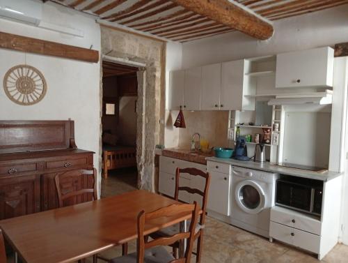 une cuisine avec une table et une salle à manger dans l'établissement Joli T2 provençal plain-pied CV cour, à Orange