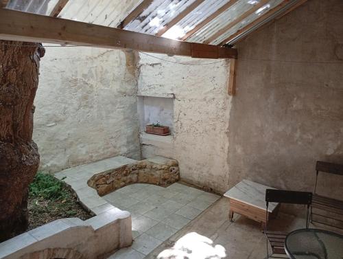 a stone room with a table and a chair in a building at Joli T2 provençal plain-pied CV cour in Orange