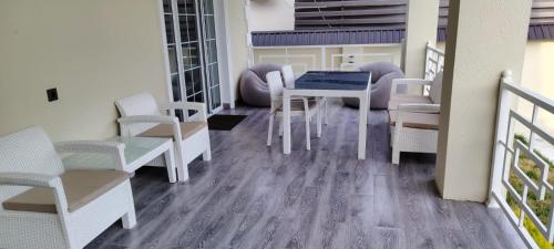 a balcony with white chairs and a table and chairs at Vendam sweet Home in Vǝndam