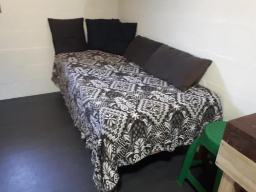 a bed with a black and white comforter in a room at Mini casa (kit net) in Florianópolis