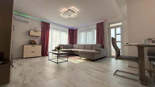 ein Wohnzimmer mit Sofa und Tisch in der Unterkunft Mara Stefania Apart Hotel Deluxe in Oradea