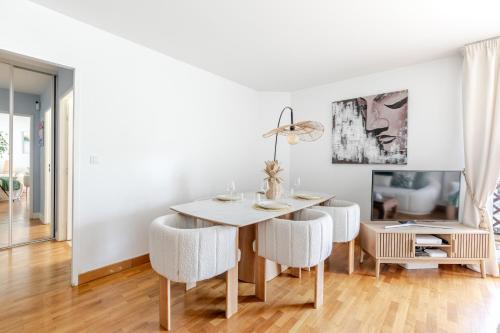 une salle à manger blanche avec une table et des chaises dans l'établissement Un ptit soleil à Paris, à Paris