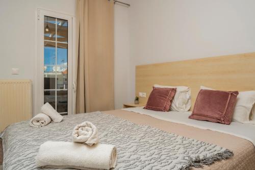 a bedroom with a large bed with towels on it at Villy Suites in Argasi