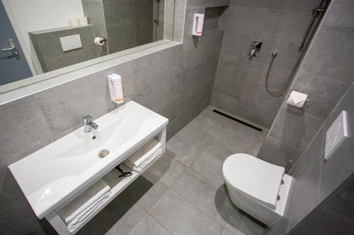 a bathroom with a white sink and a toilet at Hotel CHODOV ASC in Prague