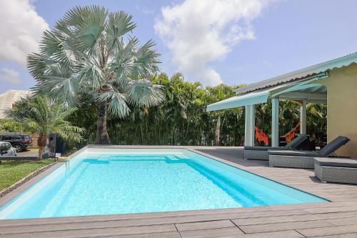 una piscina con dos sillas y una casa en Villa Trezel - Saint-François, en Saint-François