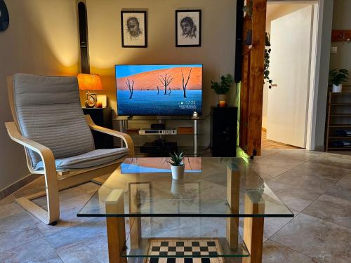 a living room with a tv and a chair and a table at Spin Inn in Kotor