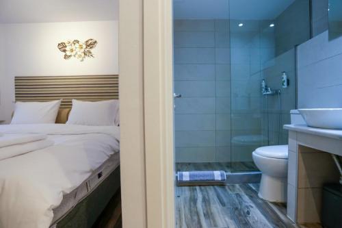 a bedroom with a bed and a shower and a toilet at Magic Holidays 444 in Mýkonos City