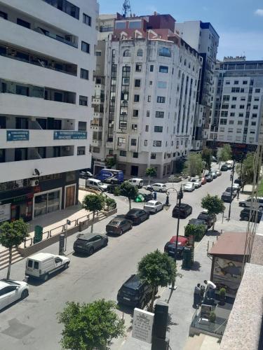 a city street with cars parked in a parking lot at dos minutos de playa in Tangier