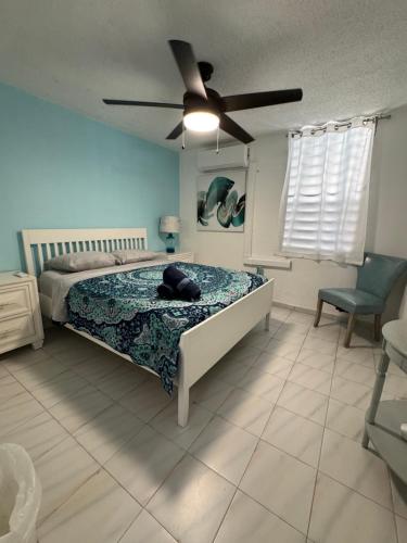 a bedroom with a bed and a ceiling fan at Casa Rosado Villa Marina Fajardo Yunque Seven Seas in Fajardo