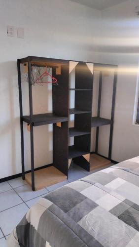 a room with a book shelf next to a bed at Don Tuga in Oaxaca City