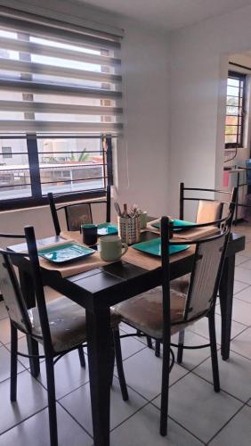 a dining room table and chairs in a room with a window at Don Tuga in Oaxaca City