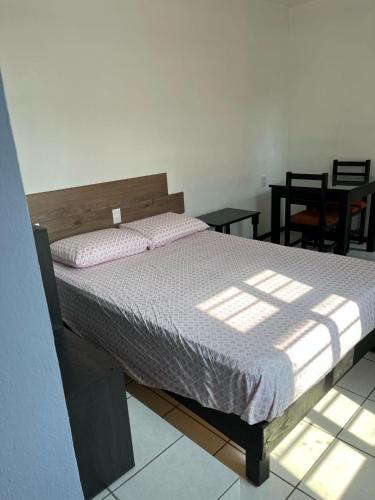 a bedroom with a bed with a wooden head board at Don Tuga in Oaxaca City