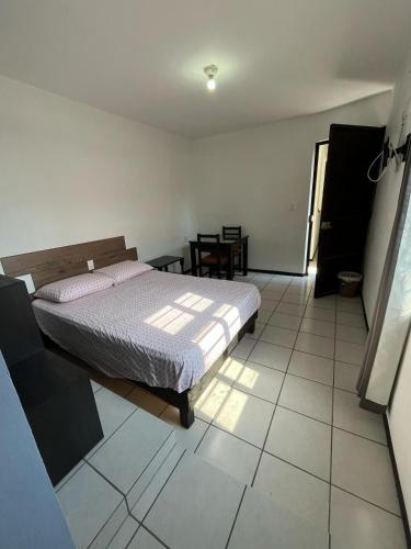 a bedroom with a bed and a tiled floor at Don Tuga in Oaxaca City