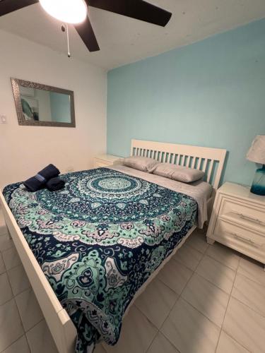 a bedroom with a large bed with a colorful bedspread at Casa Rosado Villa Marina Fajardo Yunque Seven Seas in Fajardo