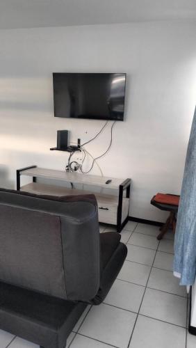 a living room with a couch and a tv on a wall at Don Tuga in Oaxaca City