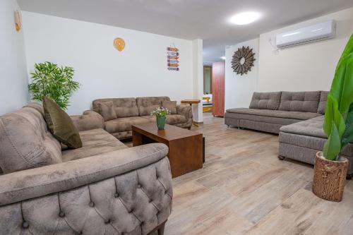a living room with couches and a coffee table at אחוזת קסם הנוף in ‘Ein el Asad