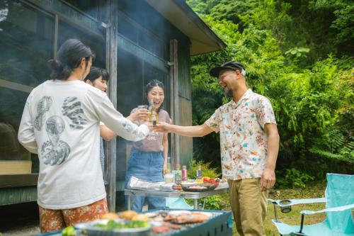 柏崎市ゲスト専用プライベートサウナ付き一棟貸し宿 In Utero的一群人站在桌子旁喝着饮料