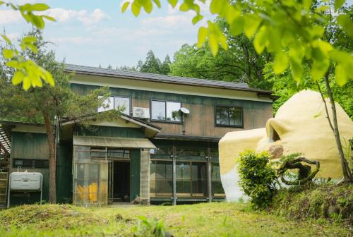 a house with a large statue in front of it at ゲスト専用プライベートサウナ付き一棟貸し宿 In Utero in Kashiwazaki
