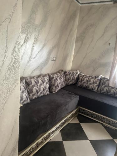 a couch in a room with a marble wall at Appartement Belyouneche in Belyounech 