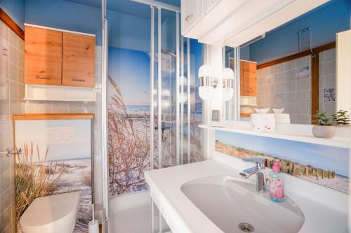 a bathroom with a sink and a window with a view of the beach at Prinz Hamlet Wohnung Pelzi 51 in Pelzerhaken