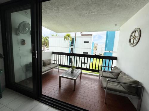 a room with a balcony with a couch and a table at Casa Rosado Villa Marina Fajardo Yunque Seven Seas in Fajardo