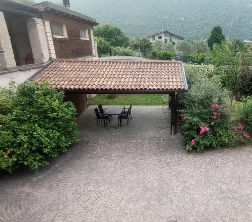 a patio with a table and chairs under a roof at Residenza Al Capitello in Ceniga