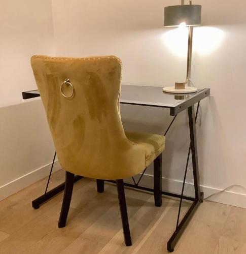 a yellow chair sitting in front of a desk at City Center Olive Grove in Kamloops