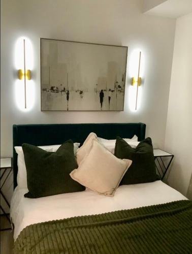 a bedroom with a bed with green and white pillows at City Center Olive Grove in Kamloops
