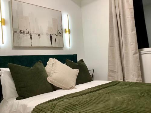 a bedroom with a bed with green and white pillows at City Center Olive Grove in Kamloops