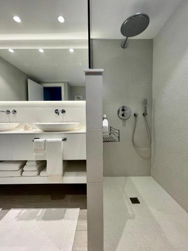 a white bathroom with a sink and a shower at S'agaró Mar in Sant Feliu de Guíxols