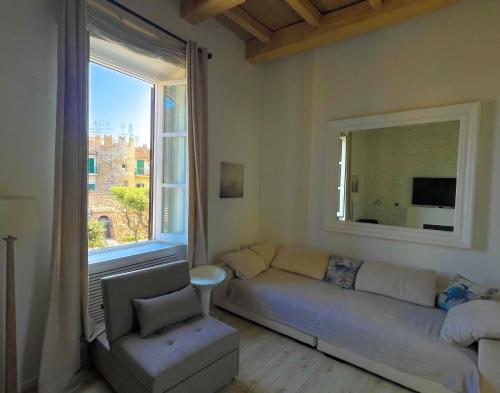 a living room with a couch and a large window at LUNA SUL PORTO Seaview Apartment - Bright and Spacious Flat in Central Nettuno, Steps from the Marina, Beaches, and Train Station in Nettuno